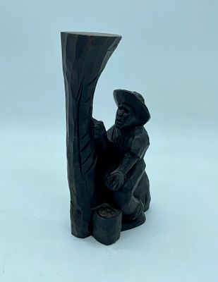 Pau santo wood sculpture depicting a man at work. The piece measures 12.5 x 6.5 x 24 cm and