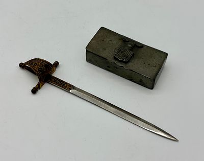 Box and letter opener. Rectangular-shaped metal box with embossed crest on top. Marked on the