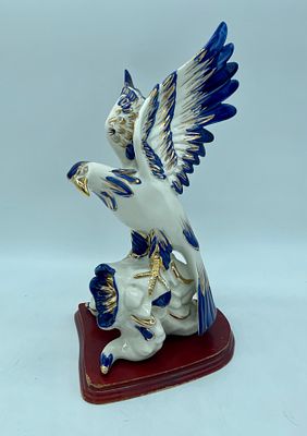 Porcelain eagle sculpture. Moulded and relief porcelain sculpture depicting an eagle on a log.