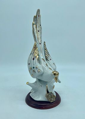 porcelain statue. White porcelain statue depicting a bird. The piece is decorated with small