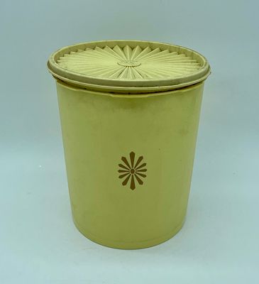 Vintage Tupperware kitchen container with lid. Cylindrical piece in yellow plastic with