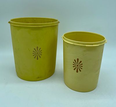 Two vintage Tupperware kitchen canisters without lid. Cylindrical-shaped pieces in yellow