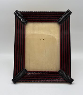 Ceramic Frame. Ceramic frame painted black and red on a wooden base.
The piece has overall