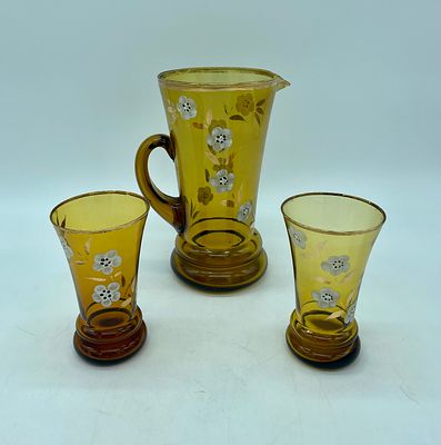 Jarro e copos em vidro colorido. Jarra com pega e dois copos em vidro amarelo, com pintura de
