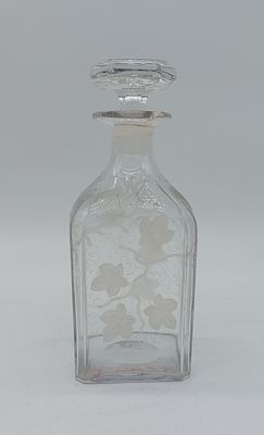 Glass Bottle
. Square shaped body with glass stopper, chiseled decoration in relief of vines and 
