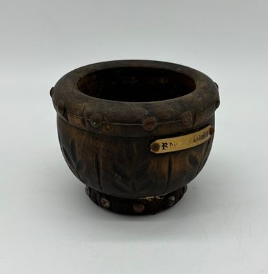 Wooden mortar base decorated with metal studs. The piece measures 12 x 9 cm and shows signs of 