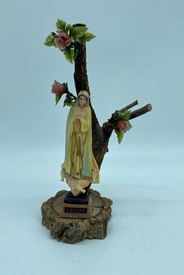 Statue of Our Lady of F&aacute;tima. Plastic statue on a still life base, branches and tree cuttings 