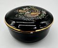 Porcelain box. Moulded and embossed porcelain box with lid. Circular black body with polychrome Image - 1