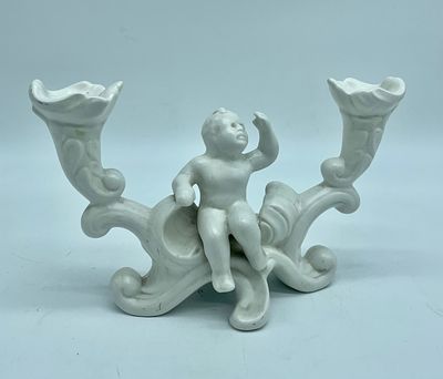 Ceramic candlestick. Moulded and embossed white ceramic candlestick depicting a boy and two 
