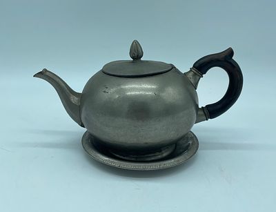 Metal teapot and plate. Bulging body with signs of use, as shown in the photographs. The teapot 