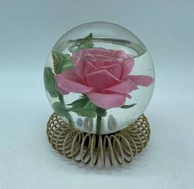 Le Rosarium globe. Glass dome with plastic flower and water inside supported by a metal 