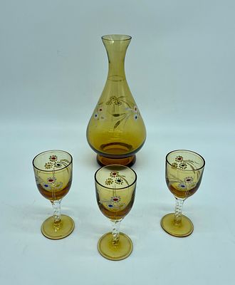 Four pieces in colored glass. A drop-shaped vase and three goblets in yellow glass with 