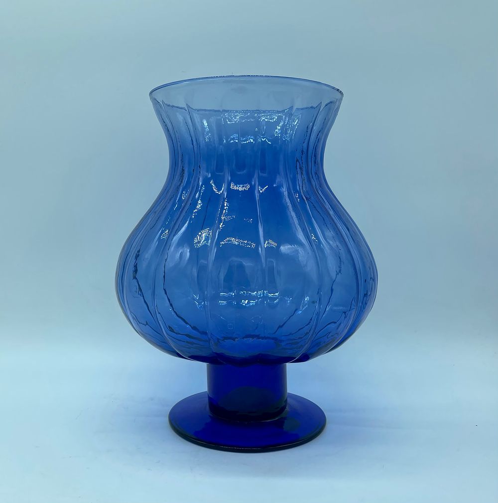 Blue glass vase. Vase with a bowl-shaped top resting on a moulded blue coloured glass base. 