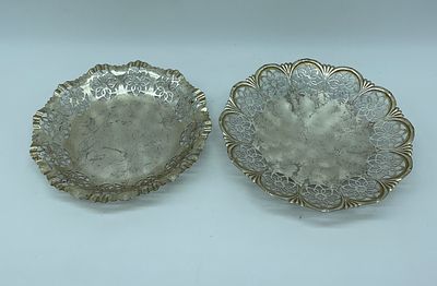 Pair of silver-plated metal ticket stubs. Round-shaped bodies with wavy and hollowed rim with 