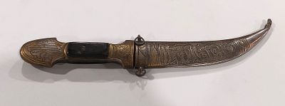 Curved Dagger
. Decorative curved dagger with silver-plated metal handle and wood accents, with 