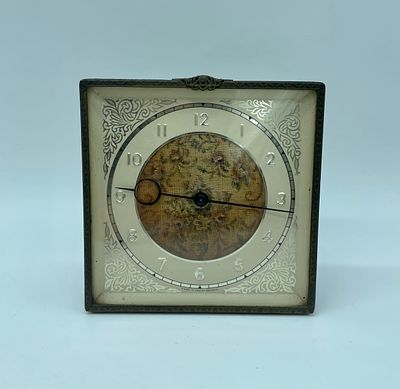 Table clock in metal frame. British-made two-hand winding clock machine in a square frame made 