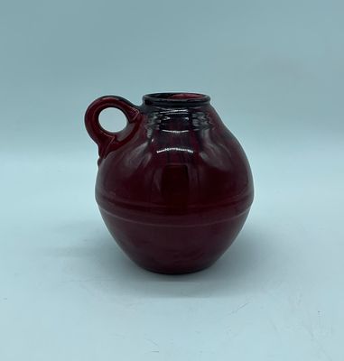 Porcelain mug. Moulded and embossed porcelain mug with bowl and handle. Painted in shades of red 