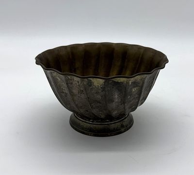 Decorative Brass Cup
. Round body supported on a round base with wavy edges, showing signs of 
