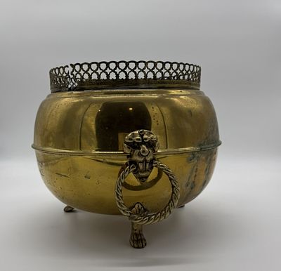 Brass flower pot
. Cylindrical body supported by three curved feet and decorative handles in the 
