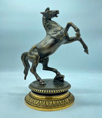Empire-style horse statue on two supports resting on a circular base with a tiled floor, gilded 