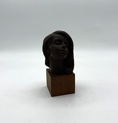 Bust of Woman
. Sculpture depicting a female bust on a square wooden base, with slight signs of 