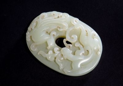 Ciondolo in giada. 7x5 cm ca. Ciondolo in giada verde con animali fantastici in rilievo. Cina.