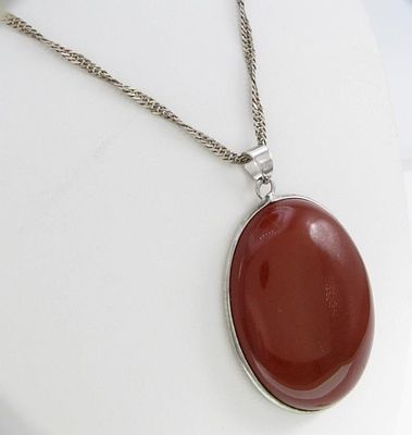 Carnelian, Sterling Pendant, Chain. A 40mm x 35mm cabochon oval carnelian stone set in an 