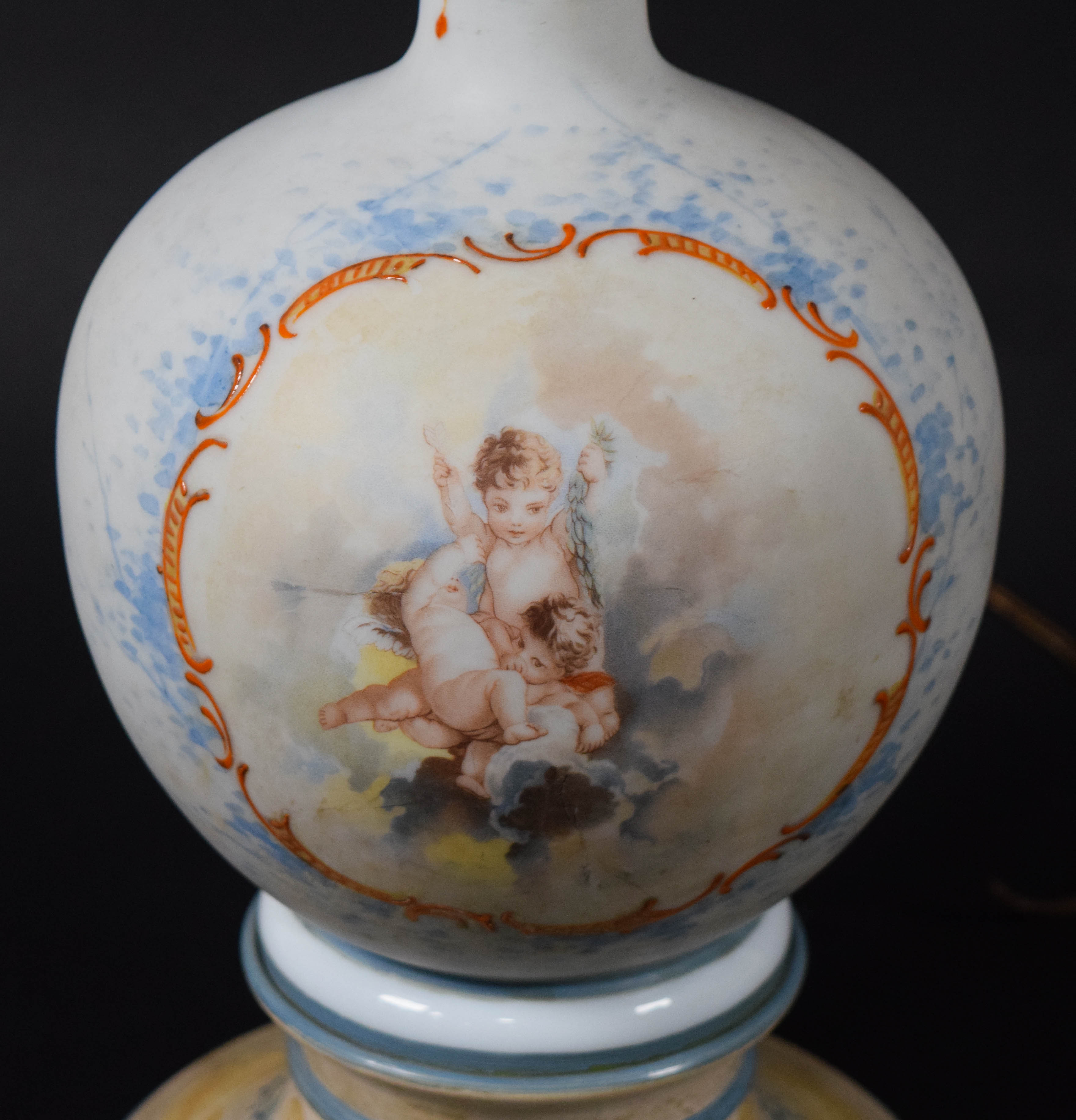 A Pair of Neoclassical Style Porcelain Vase Form Table Lamps with Cherub Decoration