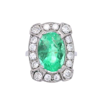 Antique Platinum Ring with Emerald & Diamonds. Antique platinum ring showcasing a vivid oval-cut 
