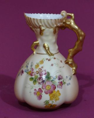 A Royal Worcester blush round bulbous jug with branch shaped handle with allover painted floral 