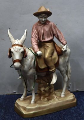 A Royal Dux group of a young boy riding a donkey, 37.5cm high