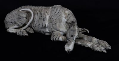 A Studio glazed earthenware model of a resting Greyhound with embossed monogram, 50cm longThe 