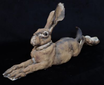 A large Studio glazed earthenware figure of a resting Hare (Both back legs restored), 59.5cm 