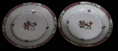 A pair of 18th Century Newhall plates on white and puce ground with coloured floral and leaf 