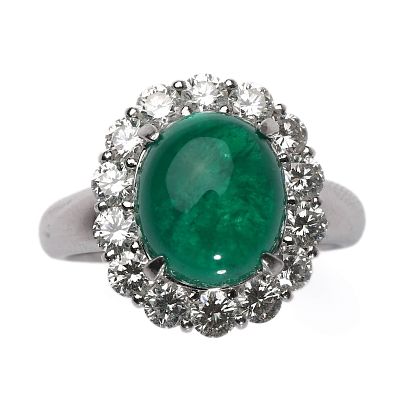 AN EMERALD AND DIAMOND RING. Set with an oval cabochon-cut emerald measuring approximately 11.8 