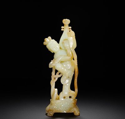A NATURAL YELLOW INLAID THREE-DIMENSIONAL FIGURINE OF A FLYING FAIRY HOLDING A PIPA FROM HETIAN. 